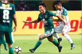  ?? ANGGER BONDAN/JAWA POS ?? DNA JUARA: Bek Persebaya Rachmat Irianto (kiri) menghalau pergerakan kapten Persatu Yan Helda Pratama dalam debutnya di Liga 2 tadi malam.