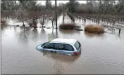  ?? JUSTIN SULLIVAN/GETTY IMAGES ?? A car is submerged in floodwater after heavy rain moved through the area on Jan. 9 in Windsor.