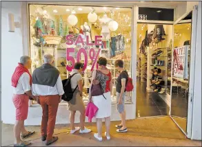 ?? AP/WILFREDO LEE ?? Shoppers mingle outside a store last month in Miami Beach, Fla. Sales in a retail category that includes department stores slipped 0.5 percent in April even as other categories, including online, gained.