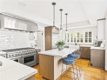  ?? AERIAL CANVAS ?? The kitchen features stainless steel appliances and pendant lights.