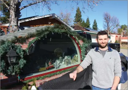  ?? PHOTOS BY THE CHRISTMAS ELF — ENTERPRISE-RECORD ?? Pierce Hutler stands by the box he built to house a Christmas town, on Mathews Drive in northwest Chico.