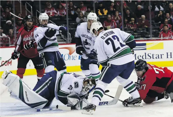  ?? — GETTY IMAGES ?? Canucks goalie Jacob Markstrom smothers the puck during Vancouver’s 3-0 loss against the Washington Capitals Sunday.