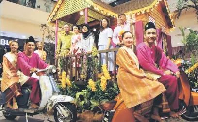  ??  ?? BERAYA DI KAMPUNG: Fatimah (berdiri, tengah) bersama Christine (berdiri, dua kanan) dan yang lain merakam kenangan sempena pelancaran Sambutan Hari Raya tHe Spring - ‘Meriahnya Kampungku’ di tHe Spring, Kuching, kelmarin.