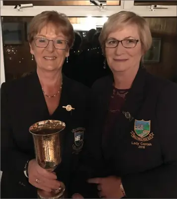  ??  ?? Lady President Mary Deegan receives the Golfer of the Year trophy from Lady Captain Patricia Foley.