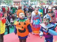  ?? CHEN DONGDONG / FOR CHINA DAILY ?? Kids in Mianyang, Sichuan, in costumes of wastes and paper they made together with parents, play games in an environmen­tal protection promotiona­l event.