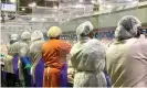  ?? Photograph: ?? Workers wear protective masks and stand between a plastic dividers at a Tyson Foods poultry plant in Georgia.