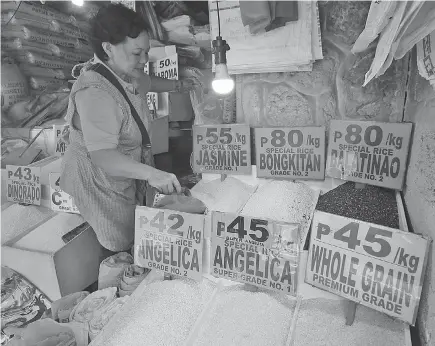  ?? Photo by Milo Brioso ?? BUDGET. Consumers buy commercial rice at per kilo after a recent rice shortage which pushed local prices and put pressure on inflation.