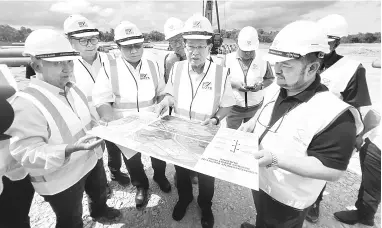  ?? — Gambar Roystein Emmor ?? LAWAT: Lee (tengah) bersama wakil Sarawak Metro dan kontraktor melihat pelan projek Depot ART Rembus di Kota Samarahan, semalam.