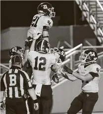 ??  ?? Gabe Hoskins is lifted into the air by Smithson Valley teammates after a touchdown in the Rangers’ 27-24 OT loss.