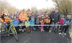  ??  ?? Keen cyclists celebrate the opening of the trails as the ribbon is cut.