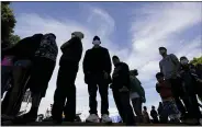  ?? GREGORY BULL - THE ASSOCIATED PRESS ?? Migrants line up for a free meal at a makeshift camp of migrants at the border port of entry leading to the United States, Wednesday, March 17, 2021, in Tijuana, Mexico. The migrant camp shows how confusion has undercut the message from U.S. President Joe Biden that it’s not the time to come to the United States. Badly misinforme­d, some 1,500migrant­s who set up tents across the border from San Diego harbor false hope that Biden will open entry briefly and without notice.