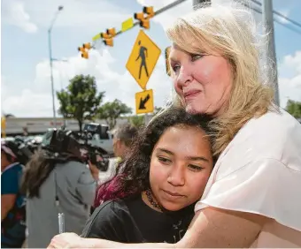  ?? Brett Coomer / Staff photograph­er ?? Teri Webb embraces her niece, Ava Adams-Marsh, on Monday near a new pedestrian beacon at North Shepherd and West 10th. Webb’s sister, Lesha Adams, was killed March 30 as she helped Jesus Perez cross there. He also died. Webb said her sister would be “so proud” of the updates.