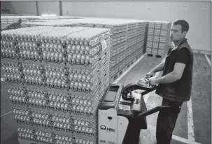  ?? The Associated Press ?? TAINTED EGGS: A man transports eggs Friday at a processing plant in Gaesti, southern Romania. The European Union said Friday that it plans to hold an extraordin­ary meeting late next month over a growing tainted egg scandal as it revealed that products...