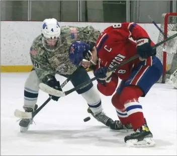  ?? JULIA MALAKIE — LOWELL SUN ?? Wilmington’s Brian Barry, left, and Burlington captain Will Curtin vie for the puck during a faceoff Saturday in Wilmington. Wilmington posted a hard-fought 1-0boys hockey win.