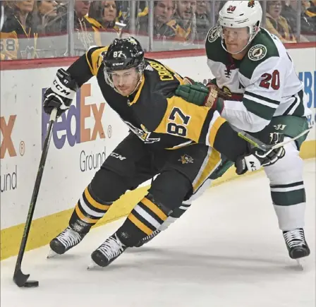  ?? Peter Diana/Post-Gazette ?? Sidney Crosby gets the edge on Minnesota defenseman Ryan Suter behind the net Tuesday in his first game back.