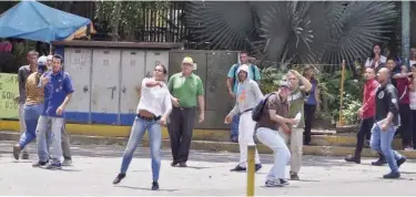  ?? Agence France-presse ?? ↑ Pro-government activists throw stones at opposition supporters in Barquisime­to, Lara State, Venezuela.