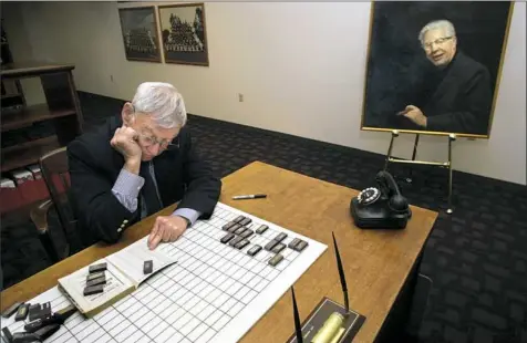  ?? Matt Freed/Post-Gazette ?? Steelers owner Dan Rooney reconstruc­ts the 1960 National Football League schedule in the library at the UPMC Sports Performanc­e Complex on the South Side in 2001. Mr. Rooney, who used to help do scheduling for the NFL, used a set of dominoes to create...