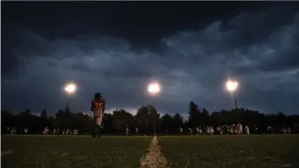  ?? MATHEW MCCARTHY, RECORD STAFF ?? Wilfrid Laurier players practise under threatenin­g skies at University Stadium. The Hawks have a good shot a beating the Lancers Saturday.