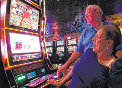  ?? Wayne Parry The Associated Press file ?? Joyce Green of Vineland, N.J., reacts to a winning spin at a slot machine as her husband, Tom, looks on in 2018 inside the Ocean Casino Resort in Atlantic City. The casino formerly known as Revel will turn a profit in May after months of steep losses.