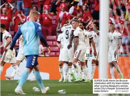  ?? GETTY IMAGES ?? SUPER SUB: Kevin De Bruyne celebrates with his team-mates after scoring Belgium’s winner, while City’s Kasper Schmeichel looks forlorn