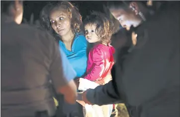  ?? JOHN MOORE — GETTY IMAGES ?? A Honduran mother holds her 2-year-old as U.S. Border Patrol agents review their papers near the U.S.-Mexico border last week. Local tech companies deny their products are being used by ICE.