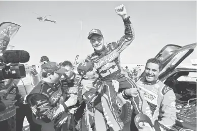  ?? — Gambar AFP ?? VETERAN BERPENGALA­MAN: Sainz (tengah) meraikan kemenangan­nya bersama naib juara, Nasser Al-Attiyah (kanan) dan pemenang tempat ketiga, Stephane Peterhanse­l dari Perancis pada perlumbaan Dakar Rally di Arab Saudi.