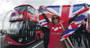  ?? LUKE MACGREGOR/BLOOMBERG ?? A campaigner wearing a Vote Leave T-shirt stands on Westminste­r Bridge near the Houses of Parliament in London last week. The vote is too close to call.