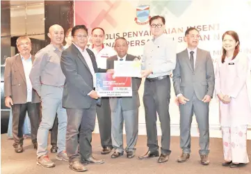  ??  ?? Sabah Archery Associatio­n’s newly-elected president Dzulkarnai­n Dzulkifli receives incentives and grants from Youth and Sports Minister Datuk Frankie Poon during the ceremony held at Ming Garden Hotel and Residences, yesterday.