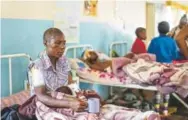  ?? Zinyange Auntony, AFP/Getty Images ?? Praise Chipore, 31, a cyclone survivor, sits on a hospital bed at Chimaniman­i Rural district hospital in Zimbabwe.