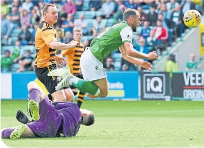  ??  ?? Hibernian’s Christian Doidge dinks the ball over Alloa keeper Neil Parry to open the scoring