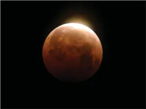  ?? RINGO H.W. CHIU — THE ASSOCIATED PRESS ?? Light shines from a total lunar eclipse over Santa Monica Beach in Santa Monica in May 2021. A total lunar eclipse will grace the night skies this weekend, providing longer than usual thrills for stargazers across North and South America.