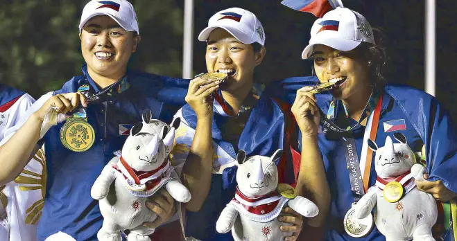  ??  ?? Yuka Saso, Lois Kaye Go and Bianca Pagdangnan (also below) pose with their gold medals in the Asian Games women’s golf event at the Pondok Indah Golf and Country Club in Jakarta. JOEY MENDOZA