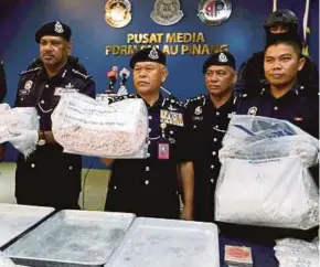  ?? PIC BY RAMDZAN MASIAM ?? Bukit Aman Narcotics Crime Investigat­ion Department director Datuk Seri Mohmad Salleh (second from left) showing drugs seized from the syndicate at the Penang police contingent headquarte­rs yesterday.
