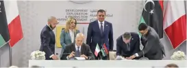  ?? (AFP) ?? Eni CEO Claudio Descalzi (front left) and Libyan National Oil Corp chief Farhat Bengdara (2nd right) sign agreement during a ceremony attended by Italy's Prime Minister Giorgia Meloni (back 2nd left) in Tripoli,