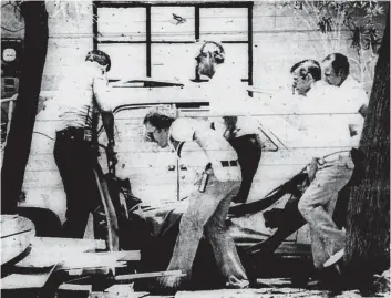  ?? MICHAEL MEISTER/THE DESERT SUN ?? Investigat­ors remove the body of one of three people found shot to death July 1, 1981, in the backyard of a home on Bob Hope Drive just outside Rancho Mirage.