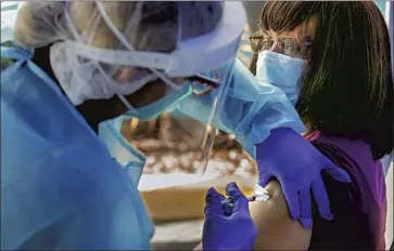  ?? I rfan Khan Los Angeles Times ?? NURSE YOLANDA JAVIER administer­s a Pfizer COVID- 19 vaccine to Bonita Brisco at St. John’s Well Child and Family Center in Los Angeles on Thursday. Two vaccines are in circulatio­n and two more are expected.