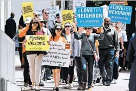  ?? STEVE HELBER/ASSOCIATED PRESS ?? Protesters voice their opposition to President Trump’s revised travel ban this month outside the 4th Circuit in Richmond, Va. The court ruled 10-3 Thursday to uphold the freeze.