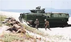  ?? AP ?? US Marines take positions as they storm the beach during the joint US-Philippine­s military exercise dubbed ‘Balikatan 34-2018’ yesterday.