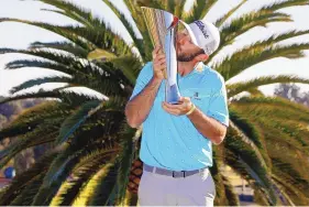  ?? RYAN KANG/ASSOCIATED PRESS ?? Max Homa kisses his trophy on the practice green after winning the Genesis Invitation­al at Riviera Country Club on Sunday.