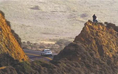  ?? Photos by Carlos Avila Gonzalez / The Chronicle ?? Tourists pose atop a rock formation south of Bixby Creek Bridge outside Big Sur, a magnet for viewseekin­g tourists.