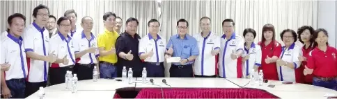  ??  ?? Lee (centre) presents a government grant on behalf of the chief minister to Federation of Miri Division Chinese Associatio­ns Sarawak, received by Hii, while others look on.