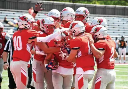  ?? BRITTANY CHAY — THE NEWS-HERALD ?? Mentor players celebrate with Steven Baird (11) during their scrimmage against Erie Cathedral Prep on Aug. 19 at Jerome T. Osborne Sr. Stadium in Mentor.