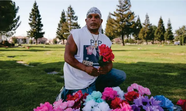  ?? Photograph: Marissa Leshnov/The Guardian ?? David Phillips places a flower bouquet on the grave of his son, Desmond Phillips, at Saint Mary Cemetery in Sacramento, California.