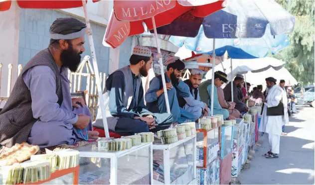  ?? Agence France-presse ?? ↑
Money changers sit at the currency exchange market along a road in Kandahar on Monday.