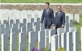  ?? PHILIPPE HUGUEN, AFP/GETTY IMAGES ?? French President François Hollande, right, and Canadian Prime Minister Justin Trudeau tour the Canadian WWI military cemetery in Vimy, France, on Sunday. The two, and members of the British royal family, were among dignitarie­s at Vimy Ridge for the...