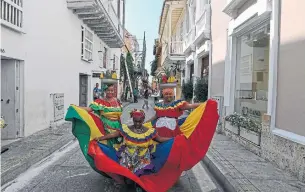  ?? JUAN BARRETO AFP/GETTY IMAGES ?? Women in costumes pose in Cartagena in December. Cartagena is a UNESCO World Heritage site on the Caribbean coast. No tourist visa is required for stays of 90 days or less.