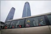  ?? NG HAN GUAN — THE ASSOCIATED PRESS ?? Workers wearing masks arrive at a work site near skyscraper­s in the Central Business District, Monday in Beijing.