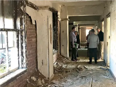  ?? Photo courtesy the city of Texarkana, Texas ?? ■ City planning staff members talk with developers during a recent walk-through of the Hotel Grim on North State Line Avenue in downtown Texarkana, Texas.