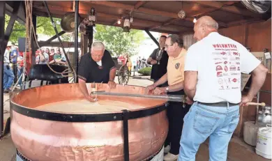  ?? CHEESE DAYS ?? Cheesemake­rs demonstrat­e how a wheel of cheese was produced in the old days using a large copper kettle.