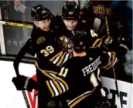  ?? BARRY CHIN/GLOBE STAFF ?? Danton Heinen (center) celebrated after scoring what proved to be the game-winning goal late in the third period